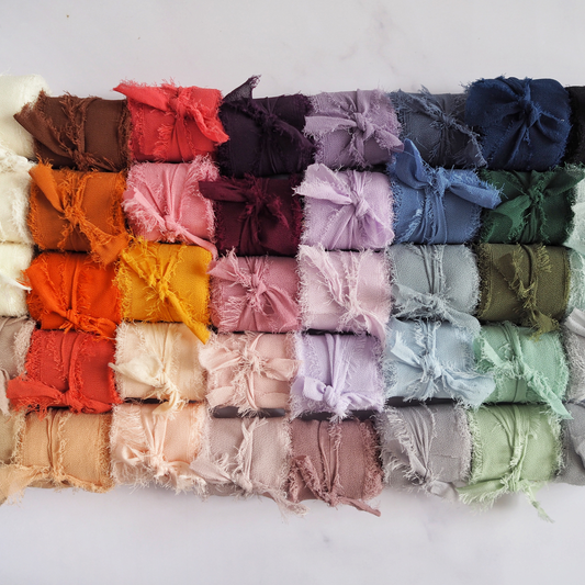 An array of chiffon ribbon rolls in various colors displayed on a surface.